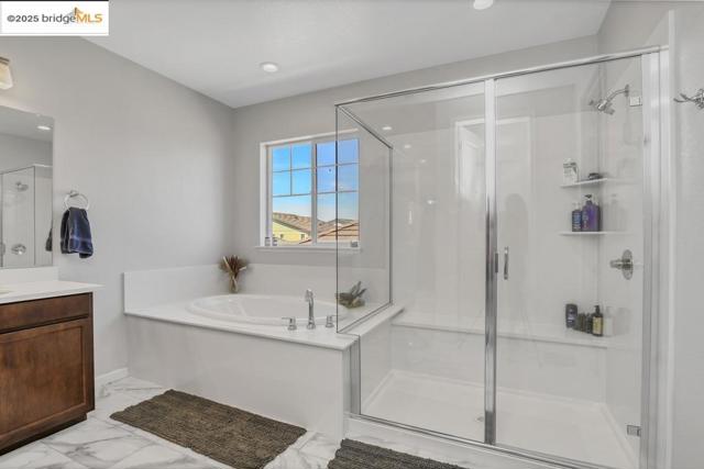 Full bath with vanity, a bath, a stall shower, light marble finish floors, and recessed lighting