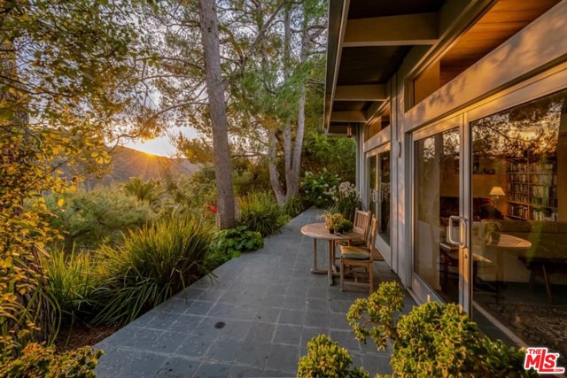 16798 Charmel Lane Pacific Palisades, California Nestled amongst majestic pine trees and with stunning views of the canyon, mountains and the ocean, this home evokes a sense of being at a coastal resort. And yet this peaceful, private and sophisticated get-away is only minutes away from the Palisades Village, Santa Monica and freeway access. Elegant simplicity and compact efficiency define the living space with walls of glass, clerestory windows and skylights that embrace the natural environment. The entry leads to the gracious and open living space with doors that open to the patio garden with magical views. A cozy den beckons you to settle in for a nice read, a movie, or engaging conversation. Both bedrooms are ensuite. The master is a retreat in itself with picture windows and a skylight to enhance the feeling of resting in nature's embrace. A large, walk-in closet also serves as a private office. Lushly landscaped with fruit trees and inviting spaces for rest, reflection, and entertainment, this mountain-garden setting is a welcome respite from the pace of City life.