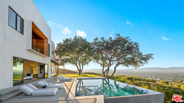 13331 Mulholland Drive Beverly Hills, California Set on a private lane off Mulholland Drive sits this one of a kind fully renovated contemporary masterpiece that ticks every box imaginable. Drive through the double driveway gates to reveal a 50ft long waterfall to greet every entry. Car enthusiasts rejoice with 3 car garages and driveway space for many more. Enter the property through the 10ft tall pivot door to immediately reveal a panoramic view over your infinity pool spanning 270 degrees. Pass the enormous living room with 30ft wide Fleetwood sliders & continue through the formal dining room to the kitchen where beauty & function live hand in hand. Bleached walnut European cabinetry, with Wolf / Subzero appliances and natural dark stone bartop make this kitchen a hub for creating and entertaining. Pick a staircase of choice to enter the upper level to access the 4 upstairs bedrooms & laundry room. Pass another pivot door to enter the premier bedroom retreat. 2 full walk-in closets, a dream bathroom & a dedicated lounge area with wrap around private decks create a full escape. Outside the magic continues with panoramic views from the infinity pool around to the grassy outdoor dining area enhanced by the mature oak trees. Total privacy and a 90210 post code make this one of a kind property an absolute must see.