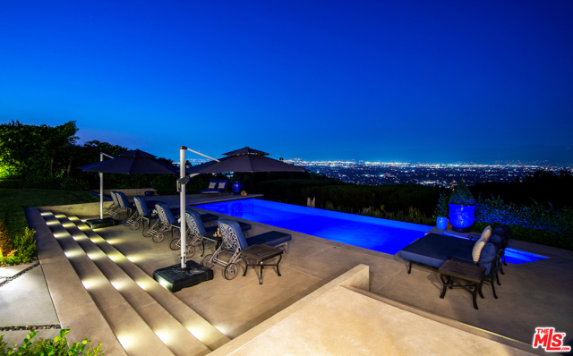 3316 Clerendon Road Beverly Hills, California Stunning extremely private guard gated Mulholland Estates chic traditional with explosive valley light views with large flat yard, pool house w/ separate suite, infinity pool, and hotel-style poolside cabana . Impressive double-height entry with private office conveniently tucked away off the foyer. 8 bedrooms and 11 baths with theater, gym, and elevator. Oversized chef's kitchen with giant islands with adjoining family room with bar opening to covered outdoor loggia with fireplace. Fabulous family dining room, formal living room and card/game room with french doors to covered patio. Stunning master suite with gorgeous views, sitting area, giant master bath and walk-in closets. Adjoining second suite next to the master which can be used for a second office. 4 additional suites upstairs with oversized guest suite with private entry and stairwell from the outside. Wonderful, timeless floorplan with loads of light and an elevator with attention to detail throughout. Community tennis and pickleball courts.