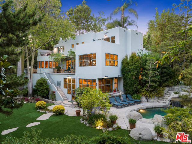 2477 Canyon Oak Drive Los Angeles, California Set in the highly coveted Oaks stands this Art Deco celebrity compound, offering the ultimate private estate experience. Spanning across three levels, the estate boasts stunning glass walls that open up to reveal lush park-like grounds, providing a seamless connection between the indoors and outdoors. The main level features a large formal living room with soaring ceilings, exuding elegance and grandeur while opening up to a large patio. The focal point of this room is a period fireplace, adding a touch of classic charm. Additionally, there is a spacious dining room, perfect for hosting memorable dinner parties and gatherings. On the upper level, the primary suite is a sanctuary of luxury. It includes a private balcony that overlooks the treetops, providing a serene and picturesque view. The suite also features a walk-in closet and a spacious private bathroom adorned with period tile, further adding to the property's character and charm. The chef's kitchen features stainless steel appliances, tons of counter space and a quaint breakfast area that overlooks the private front courtyard. The lower level of the estate offers an abundance of space and amenities for entertainment and leisure. An oversized family room provides a comfortable area for relaxation, while a fully equipped gym allows residents to maintain an active lifestyle. Adjacent to this, there is a well-appointed wet bar that spills out to the pool area, creating the perfect setting for entertaining guests. The property also includes a formal guest suite with a private entrance and a full bath, ensuring privacy and comfort for visiting guests. The outdoor area of this estate is truly exceptional, featuring a stunning flat yard with an abundance of mature trees that add a sense of natural beauty and tranquility. A custom pool with a spa adds a touch of luxury and provides a refreshing escape during warm days. A cabana complements the pool area, providing a shaded space to relax and unwind. The entire outdoor space is meticulously manicured and designed to offer an extremely private and exclusive experience to entertain all year long. This property offers a one-of-a-kind opportunity to own an exquisite private compound in the highly sought-after Oaks area. With its elegant design, lush park-like grounds, and luxurious amenities, it stands as the epitome of a private estate, providing an unparalleled living experience for its fortunate residents.