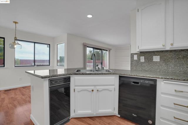 Kitchen featuring a peninsula, white cabinets, dishwasher, decorative backsplash, and recessed lighting