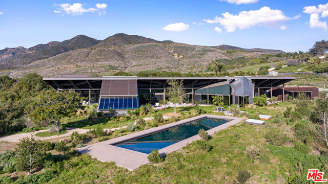 Embrace the opportunity to own an Architectural Masterpiece in one of Malibu's most beautiful settings.  Set on four flat acres in coveted Bonsall Canyon, this elevated property is accessed through two sets of entry gates, and offers total privacy along with breathtaking mountain, canyon, and ocean views.  Designed by renowned architect Ed Niles FAIA, the meticulously crafted concrete, steel, and glass residence seamlessly blends world-class modern architecture with the natural beauty of its surroundings.  Completed in 2022, the home took nearly 20 years to build, and is an exceptional vision of modernist architecture, set apart from the more common "white box" Contemporaries currently dotting the Southern California Coastline.  The home's design springs to life from a huge wing shaped butterfly roof that spans over 7,200 sq. ft. of interior living space and is cantilevered above another 1,500 sq. ft. of stone decks.  The entire home is wrapped in solid walls of glass offering stunning views in every direction and erasing the line between indoor and outdoor living.  It's calm coastal color pallet, Italian marble floors, artisan hand painted pillars and the infusion of abundant natural light soften the dynamic architecture and evoke a sense of serenity and warmth.  The interior space consists of six separate wings spreading out like the fingers of a hand along a long center hall running the length of the structure.  Each wing has its own identity and relationship with the surrounding nature.  On one wing is a spectacular living room and study, while on another is an open great room combining gourmet chef's kitchen, dining area and family room - all perfect for relaxation and entertainment.  Each wing looks out on to the infinity edged pool, landscaped patios, ocean and mountains beyond.  They are separated by stone decks and gardens yet visible to each other through the home's translucent glass walls.  The luxurious primary bedroom suite is on its own private wing and has a gorgeous spa-like bathroom with glass encased shower, Italian marble soaking tub, and oversized custom-built closets.  There are four other bedrooms - all with stunning views.  Outdoor amenities include a swimming pool and spa, full-service outdoor kitchen/ BBQ area, dining pavilion, and professional equestrian facilities with 4-stall barn, professional jumping arena, ample pastureland, and ready access to over 400 miles of riding, hiking, and biking trails at the end of Bonsall Canyon.  Or, if you prefer the beach, it's just a short golf cart ride away driving safely through a nearby underpass.  Plus there are approved plans for two additional guest structures on the property.  Don't miss this rare opportunity to enjoy Malibu living at its finest in one of the most architecturally significant properties in Southern California.