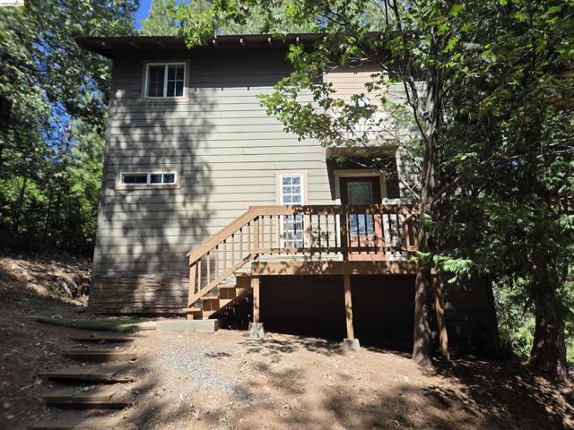 Two-story residence featuring horizontal siding, a wood-finish deck with railings, and a multi-pane glass entry door