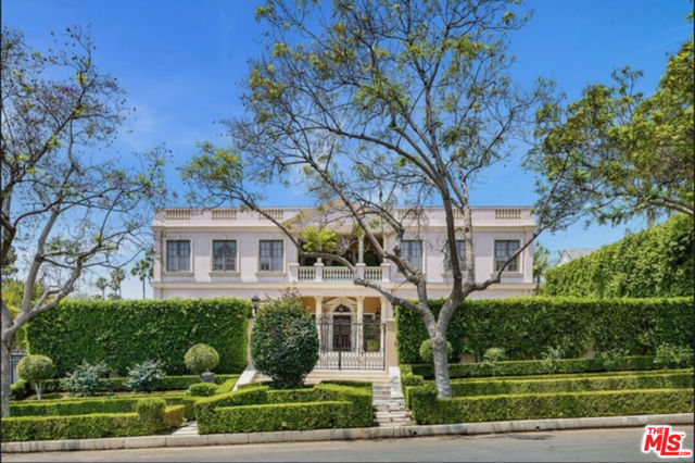 This Grand Georgian Estate is located in the prestigious flats of Beverly Hills. The interior features six bedrooms and 11 baths, an impressive two-story entry with marble floors, large rooms with high ceilings, a gourmet kitchen with an adjacent sun-filled breakfast room, an elevator, double powder rooms, and a Spacious primary bedroom with fireplace, separate his and her baths, large walk-in closets, and a large private balcony with views of the pool and city lights.