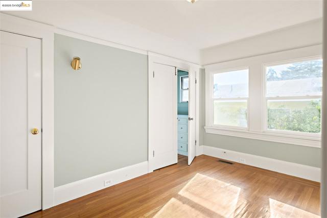 Unfurnished bedroom with light wood-style floors and multiple closets