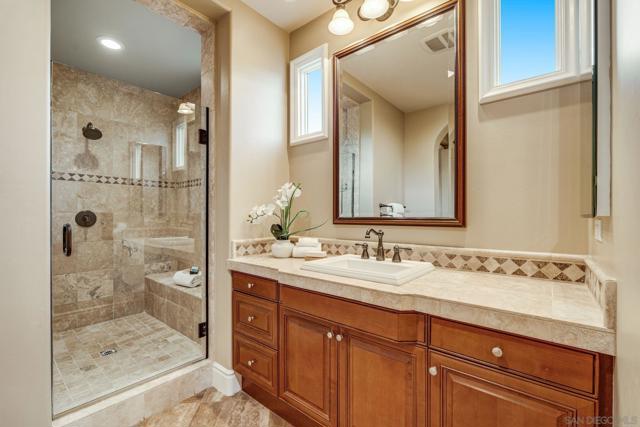 Luxurious dual primary baths with separate spaces. One side features a walk-in shower, vanity, water closet, and walk-in closet. The other offers a large vanity, oversized shower, soaking tub, makeup vanity, water closet, and expansive walk-in closet.