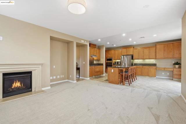 Kitchen with open floor plan, a breakfast bar area, a center island with sink, recessed lighting, and stainless steel appliances