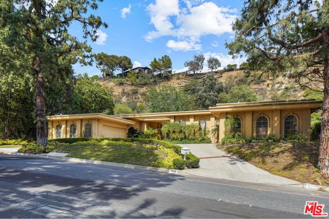 1856 Loma Vista Drive Beverly Hills, California Sited in the iconic Trousdale Estates, awaits this sophisticated traditional home on one of the most sought-after streets. Spanning over 5,000 SF of living, the luxurious retreat is beautifully highlighted by grand archways, oversized windows, French doors, and skylights for an abundance of natural light. Enjoy your favorite meals in the open kitchen with breakfast nook, ample cabinetry, and stainless-steel appliances. Additional home features include spacious master suite, generous guest rooms, sauna, office, laundry room, maids room, travertine & limestone counter, oversized motor court, and so much more. Relax under the California sun in the sprawling yard with large grassy pad, pool, covered patio for al fresco dining, and lush landscaping. Only a stones throw from the best of Beverly Hills, this enchanting gem is a remarkable value with endless potential.