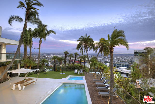 9444 Sierra Mar Place Los Angeles, California Featuring jetliner city views & located at the top of the Hollywood Hills, sits this contemporary masterpiece w/ city views, warm interior finishes, & unparalleled amenities. Double metal doors expose entry ctyd feat. views from DTLA to the ocean. Enter light & bright open living room w/ walls of glass & high ceilings. Kitchen offers high-end appliances, wood paneled cabinetry, breakfast bar & covered patio. Elegant dining room & adjacent patio complete the first floor living area. Lower level features sun-drenched family room w/ sliding doors that expose resort-like yard. Enjoy pool/spa, grassy pad, palm trees & promontory views. Property is complete w/ theatre & attached guest house. Also available is 9442 Sierra Mar Pl ($5,495,000). 9442 sits adjacent to 9444, & the 2 can be combined to create a 30,679SF lot to build a 12,000SF world-class estate. Approved plans by Vantage Design Group are for a gated compound featuring 8BR, 13BA, full-level spa, 1,500SF master BR w/ terracing.