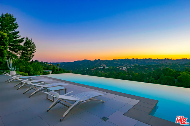 2791 Ellison Drive Beverly Hills, California Private and gated lavish modern entertainer's paradise on a quiet cul-de-sac.Enter through a dramatic foyer to a great room with soaring 15ft ceilings ,Murano glass chandelier and vanishing glass walls for a seamless transition from indoor to outdoor allowing an unobstructed sight of an infinity edge pool with breathtaking views.A luxurious master bedroom on the first floor with dual bathrooms and large walk-in closets.Top of the line kitchen with Miele appliances and cedar crocodile stone counter top .Additionally three en-suite bedrooms , media room, office ,maids room,an extensive outdoor living area with fireplace , tv, dinning and kitchen complete this serene masterpiece for a flawless Californian lifestyle! 8 min from the Beverly Hills Hotel