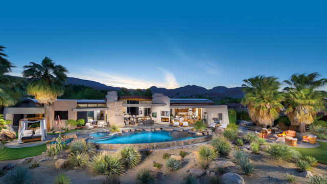 Desert living at its finest. Unequalled Outdoor Living with two fireplaces, TVs, sunbather's deck, fire pit, artificial turf, indoor/outdoor bar, infinity-edge pool, spa, outdoor dining and barbecue center with unobstructed views of the green, fairway, waterfalls and Eisenhower Peak. One of four custom barrel ceilings is featured at the main entry and frames a contemporary Living Room, with dramatic fireplace, step-down bar and pocketing walls of glass; open to dining room, family room and outdoor.  A large breakfast island with bar seating, high-gloss cabinetry and custom accent lighting, professional-grade appliances, family dining area and spacious family room with fireplace. Master Suite with designer furnishings and finishes, fireplace and TV; spa-inspire bath includes morning bar, dual vanities, soaking tub, shower, boutique-style closets, washer and dryer; direct access to spa and outdoor patio. Attached Guest Wing accessed from inside or outside of the main residence with three separate suites with built-in media, full baths, closets and access to private patios; shared living room with powder bath, fireplace and TV; kitchenette with breakfast seating and outdoor patio. Home Theater with interactive seating, acoustic wall treatments, custom lighting, 'night sky' ceiling, snack bars, refrigerators, icemaker and dishwasher; Home Gym and powder bath. One-of-a-kind finished air-conditioned garage with bar and extensive storage; six fireplaces; professionally furnished