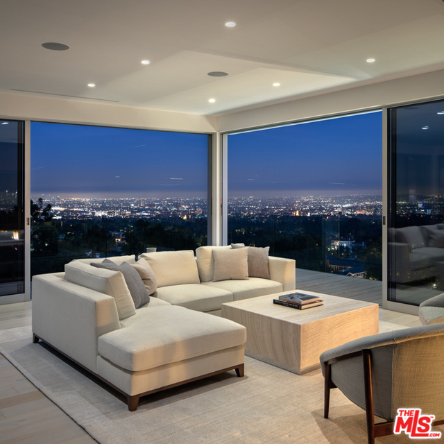 9894 Beverly Grove Drive Beverly Hills, California Nestled quietly atop a Japanese Garden, minutes from the Sunset Strip, The Residence at Beverly Grove offers respite within nature. As you approach you are welcomed by the ease of a slow moving gate. The front door opens & you are greeted with a flood of sunlight from the large skylight above. White oak floors & reclaimed walnut panels compliment the natural surroundings. With large glass panels that slide open to extend the indoors out & the outdoors in, decks to gaze upon the gardens & 180 degree views of LA, the residence becomes as much a part of the garden as it is a jewel within the landscape. White in contrast to the bamboo trees below, the natural beauty of the home blends seamlessly while still maintaining an identity all its own. The residence feels light as it rises above the shimmering light blue water of the pool below. This home is a true masterpiece that must be viewed to be truly appreciated.