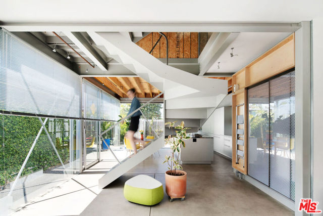 528 Grand Boulevard Venice, California Winner of the AIA 2020 Merit Award for Residential Architecture, The "Y" House is a stunning live/work residence designed by Cigolle X Coleman Architects for themselves. Featuring 2 bedrooms, a studio & 2 1/2 baths, the house is tucked behind Abbot Kinney, just blocks from the beach. The spiraling switchback steel staircase at the center of the house organizes the living spaces. The contrast of materials - from stainless steel & perforated anodized aluminum, to raw plywood and hand-plastered surfaces - blend refined cutting-edge details with an artistic Venice aesthetic. The open plan ground floor looks out to the garden and patio through walls of glass and contains living, dining and kitchen - outfitted w/ Bulthaup cabinetry, Miele appliances & Marmoreal countertops. The private master suite encompasses the entire middle level and offers custom cabinetry, Poliform closets, a stand alone tub and walk in shower. On the 3rd floor you'll find a second bedroom with en suite bath, along with a large studio/playroom with its own kitchenette - a very adaptable space flooded with natural light. The house boasts radiant heated concrete & hardwood floors throughout, Fleetwood doors & windows as well as a customizable Lutron lighting system. The rooftop deck offers dramatic views of the city and Santa Monica Mountains while still maintaining a feeling of privacy.