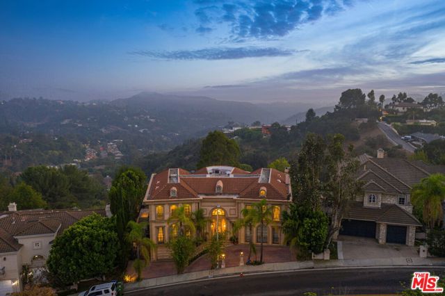 3171 Deep Canyon Drive Beverly Hills, California Fall in love with this luxurious Beverly Hills Villa, enveloped by multi-million dollar views. A rare offering, this grand estate sits on a sprawling double lot totaling approx. 24,000 SF w/endless potential including space for a tennis court. Be greeted by soaring palm trees, motor court & garage. Double height entry accented by crown molding details, floor-to-ceiling windows & French doors to yard. Formal living w/fireplace, backlit cove ceilings & sets of glass doors. Sleek gourmet kitchen w/top-of-the-line ss appliances, 6-burner range, island, wood cabinetry & breakfast nook. Spacious master w/balcony & bath w/jacuzzi tub, dual vanity sinks, glass shower & 2 walk-in closets. Amenities include wet bar, formal dining, den, wood panel library w/full bath, room for elevator, 2 bidets & so much more. Expansive deck w/pergola, serene greenery & stadium quality lighting. In the heart of prestigious Beverly Hills Post Office & newly refurbished, this enchanting Villa is a true dream.