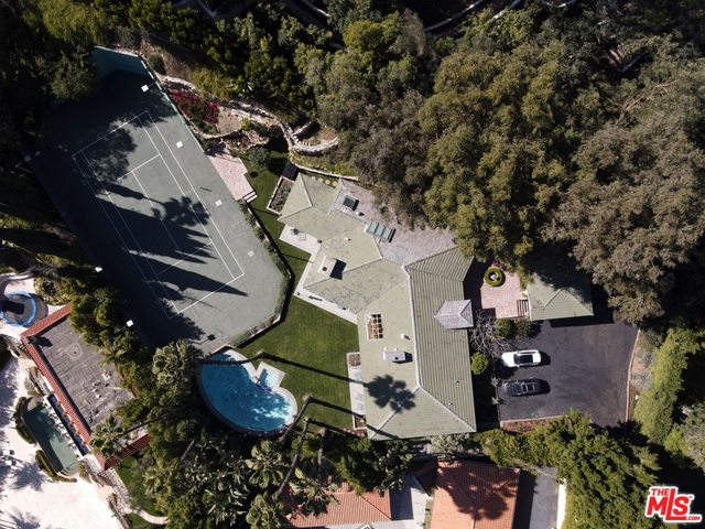 1009 N Beverly Drive Beverly Hills, California What's behind the red door?! Understated elegance. Privacy. At 3/4 of an acre, this flat, tennis court property is hidden behind unassuming gates. Exquisitely updated with a designer's eye, this once 4br/5ba home has been converted into a 2br/3ba home, creating a Master Suite fit for royalty, and charming guest suite. The floorplan was opened, vaulted and brightened up to create a fabulous kitchen and dining area, a grand living room with bar area, all while maintaining a formal dining room complete with fireplace and floor to ceiling windows. The grounds boast a pool and spa, citrus trees, rose garden, various vegetable gardens, and your very own CAVE at the far end of the Tennis Court. Enjoy the existing home with ease, or GO BIG and build your castle. Walking distance to the Beverly Hills Hotel, incredibly quiet and peaceful, and full of potential!