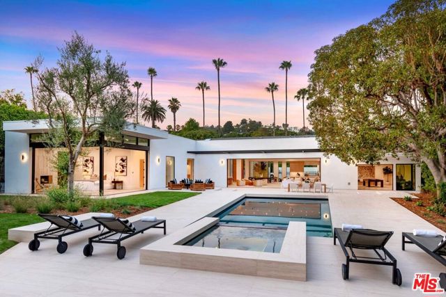 410 Doheny Road Beverly Hills, California Luxury and tranquility meet in this captivating reimagined single-story sanctuary, situated behind private gates on a sprawling over half-acre lush flat lot in one of Beverly Hills' most exclusive enclaves, masterfully reconstructed with an open and balanced modern design. Rare indoor-outdoor harmony is meticulously defined throughout this 4 bedroom 4.5 bath oasis that seamlessly transports visitors through its open, light-filled floor plan to the spacious pool and garden grounds. Conceived and stunningly executed by Corr Contemporary Homes. Exceptional modern design and curated details make for a distinctive masterpiece impeccably situated North of Sunset Boulevard and South of Trousdale, and close distance from the historic Greystone Mansion. Gated and private, the landscaped exterior features a spacious motor court. An artfully placed open-air glass atrium showcases a Japanese maple tree and oversized solid oak front door offering breathtaking curb appeal - the dramatic entryway, with pitched ceilings and skylights above the sweeping, lavish living space. The massive great room features large-format Italian limestone flooring throughout and high ceilings, bathed in natural light from multiple skylights with dining, living, and bar areas, and a fully upgraded and meticulously state of the art cooks kitchen. Just beyond the gas fireplace, through an oak pocket door, is the spacious family room with additional skylights and rear Fleetwood doors to the backyard, offer an elegant homage to early Californian modern design. The grand master suite is the perfect blend of sophistication and comfort, with Travertine stone walls and a nested gas fireplace. The luxurious master bath includes double integrated marble sinks, a vast backlit mirror, free-standing soaking tub, spacious stand-up shower, and inspiring extensive walk-in closet with custom LED lighting and lit center display case. The suite's 90-degree pocket doors offer warm natural light, a panoramic view, and access to the sprawling and secluded backyard retreat complete with an oversized pool, infinity-edge spa, and entertaining areas; surrounding hedges make a private escape. The grassy yard with mature landscaping offers ample space for a guest house and sports court. This breathtaking showpiece is vigorously reimagined to ensure every tasteful touch and thoughtful feature will continually dazzle and impress the homeowner and their guests. Redefining the California dream home in remarkable style and striking sophistication.