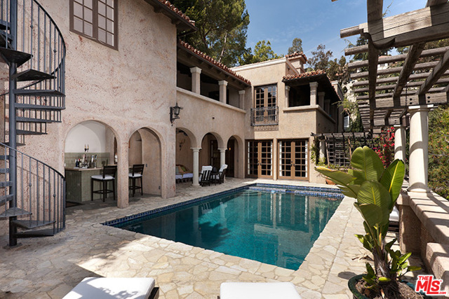 1316 Beverly Grove Place Beverly Hills, California This magnificent Mediterranean View Estate is situated at the end of a private road behind gates. A long driveway opens into a spacious motor court. A dramatic courtyard entry w/ fountain leads to the impressive interiors with high ceilings & beautiful hardwood floors. A spacious living room w/ frplc, fantastic kitchen w/ center island, dining area and family room w/ frplc are offered. An outdoor dining area w/ frplc offers the perfect space for dining al fresco. Large covered & beautifully furnished terraces found throughout allow for seamless indoor-outdoor living. The over-sized master suite is located on the main floor & features a spacious sitting area, frplc, large walk in closets & dual baths. The 2nd floor offers 3 spacious bedroom suites & a large 2nd family room w/ bonus kitchen & wine cellar that open to the yard. The resort-like grounds extend to the fantastic pool area that features a bar, lanai and sweeping city views.