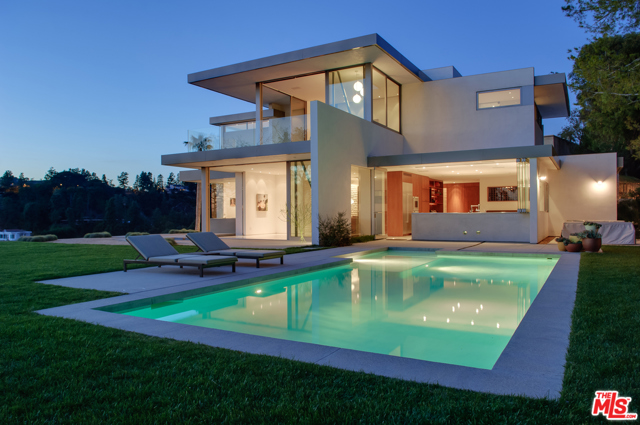 1133 Miradero Road Beverly Hills, California Miradero is very livable, flexible and less fussy. A jewel box in an A+ location in the heart of Beverly Hills. Set atop a promontory with total privacy & unobstructed views from downtown to the ocean to The Getty. Stunning landscaped grounds include mature trees that provide just enough privacy & also frame a rare 180 degree glittering view of Los Angeles. Architect John Bertram, whose portfolio includes restorations of historic Neutras, has applied his hand to five historic Neutra residences, including the Brown and Hammerman houses in Bel-Air. Miradero is designed in an international style using a palette of smooth coat stucco, steel, terrazzo, natural cork and split-face limestone used for the rough-hewn exterior and interior walls. The rooms are visually seamless architectural elements that offer an array of quietly surprising details. In the sun-drenched master bedroom, Bertram created a minimalist display with three sizes of Wohlert pendant lamps by Louis Poulsen hung at different lengths. Floor to ceiling walnut panels, moving walls of Fleetwood doors, pocket doors and wide-view windows with concealed frames. Built using green technology, utilizing solar power, and the highest efficiency products. This home is a gem that is ready to be yours!
