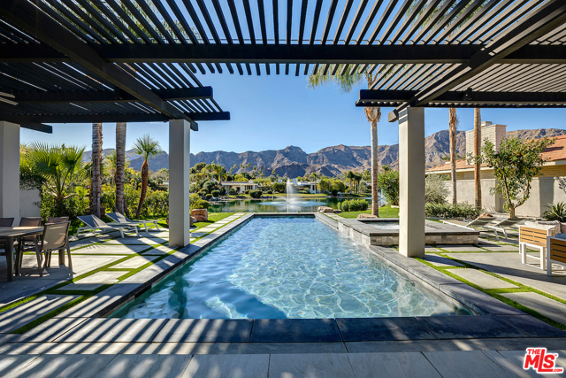 8 Deerfield Court Rancho Mirage, California Stunning, timeless & elegant modern perfectly situated at the exclusive Club at Morningside. Jaw dropping southern mountain views and exposure combined with glistening lakefront views to enjoy nature arrive with the early morning sunrise & skies at sunset. Carefully crafted with a flawless designer eye and finishes like warm travertine-marble floors & high ceilings. Every room designed to seamlessly connect to the other, inviting in the landscape from every vista thru endless walls of glass & water features. Bright, airy home with an enormous great room, true chef's kitchen with Sub Zero, Miele appliances & chic white cabinetry, Carrara marble countertops and two islands with waterfall edges for cooking & entertaining. Stunning master suite with fireplace, private sitting area, two master baths & two custom closets for the ultimate in desert luxury on vacation or as a main home. Fabulous covered patios, swimmer's pool & spa, full outdoor kitchen with beautiful landscaping all around.