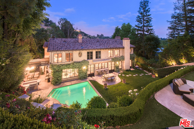 3145 Abington Drive Beverly Hills, California Tucked away in Beverly Hills' Deep Canyon, this resort style Tuscan Villa is private, gated, and perfectly placed on a quiet cul de sac. A beautiful front garden and grand custom iron French Doors lead into a 2-story entry with exquisite ironwork and dark hardwood floors. Elegant fireplaces are found in both the living & dining rooms, accompanying the tranquil views of the beautiful gardens. The chefs kitchen with center island, stone counters, breakfast bar, also features a dual sided fireplace. Huge master retreat with fireplace, lounge area, custom walk-in closet and bath with soaking tub, and dual vanities are surrounded by romantic views of the grounds. Separate dressing room with two custom lit vanities. Outdoor patio with fireplace off of the kitchen is the perfect setting to dine al-fresco. Enjoy your own hillside Gazebo overlooking the pool, waterfall, outdoor kitchen, outdoor bar and flat grassy yard.