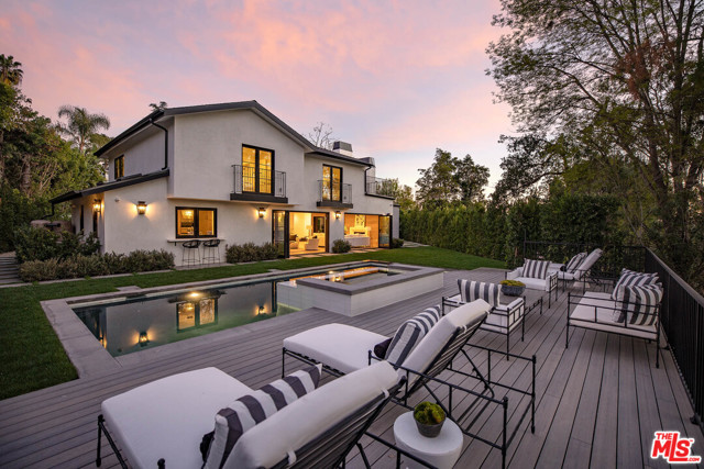 9607 Wendover Drive Beverly Hills, California Luxury California living at its finest, come home to this newly re-imagined Beverly Hills estate. Sited in a world class locale, this stunning retreat is minutes to the best shops, restaurant & in Benedict Hills HOA w/community tennis courts & security patrol. Be mesmerized by the curb appeal as you are greeted by meticulous landscaping & soaring trees which lead you to the dramatic double height glass door entry. With a sweeping open floor plan, the home boasts endless entertaining opportunities & features a decadent bar, wine cellar, formal dining & multiple living spaces w/accordion glass doors for an indoor/outdoor flow. At the heart of the home is a voluminous formal living w/fireplace & floor-to-ceiling windows. Gourmet kitchen w/Wolf appliances, eat-in island, pocket windows to outdoor bar top, & walk-in pantry. A dramatic staircase brings you to the 2nd level with generous guest suites, laundry room, & private primary wing. Spacious master w/marble clad fireplace, lounge, French doors to the sweeping patio for morning coffee or evening drinks, and en suite bath w/dual vanity sink, glass shower, soaker tub and two well-appointed walk-in closets. Whether enjoying a dip in the pool or al fresco meal from the BBQ, the yard is suited for any event & is enveloped by greenery for the most serene environment. A true dream built w/no-expense spared!