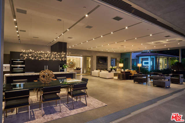 1975 LOMA VISTA Drive Beverly Hills, California A five star Bali resort - in the heart of Trousdale Estates. One of the most organic and spectacular properties in Beverly Hills! This Zen inspired contemporary masterpiece boasts a 60' x 40' great room "wall of glass" with 100 feet of automated Fleetwood sliding glass panels - providing abundant natural light and creating indoor/outdoor living at its finest. The automatic glass panels open to a Balinese-inspired outdoor oasis with a zero-edge infinity pool that appears to float inside the home and a large Koi pond with waterfall and fire pit. A Porcelanosa and Miele designed kitchen overlooks the outdoor living area with a large fully-equipped outdoor kitchen. The master suite is adorned with a wall of stone and fireplace and includes a deck with a fire-pit overlooking the Koi pond and a serene view of the expansive backyard and incredibly stunning pool. The ultimate in Zen, serenity and elegance for the sophisticated buyer.
