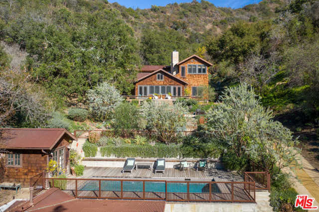 9797 Easton Drive Beverly Hills, California This apx. 5-acre gated estate, sited at the end of a cul-de-sac in a coveted Beverly Hills Post Office location, showcases the collaborative efforts of top architects and designers in creating a rustic yet refined retreat, where those seeking to be one with nature can experience utmost privacy and live comfortably in unsurpassed style. Enter the double gates to first approach the guest house, with its own living area, kitchen, separate bedroom and attached garage, currently used as a gym. Proceed to the main house, stopping to appreciate the pool and pool house, seamlessly integrated into the landscape, and offering resort type amenities, including a bathroom with an outdoor shower. The main house, with organic beauty in every detail, has a great room, study, sunroom, and three bedrooms, with the main bedroom suite located on the main floor. Outdoor appointments include manicured gardens, vegetable planters, wood decks, a gas fire-pit, fireplace, outdoor shower, hiking trails, a bubbling hot tub and abundant onsite parking. For those drawn to San Ysidro Ranch in the summer, and Aspen in the fall, find your sanctuary here in the heart of Los Angeles, conveniently close while worlds apart.