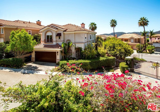 1460 Paseo De Oro Pacific Palisades, California This beautiful four-bedroom, four-bathroom home is set on a gated and private street atop the Palisades Highlands. Upon entry, guests are welcomed by an open floorplan with the living room with soaring ceilings inviting in abundant natural light as it leads towards the formal dining room. Through architectural archways, the chefs kitchen with an island, stone countertops, and sophisticated wood paneling is perfect for preparing large dinners for guests or intimate meals. Upstairs, find all four bedrooms including the luxurious master suite featuring a large bedroom with a fireplace and deck with ocean views, as well as a spa-like bathroom with an oversized shower, separate tub, and dual vanity. The backyard boasts fruit trees and a water fountain. A laundry room and direct-entry two-car garage complete the home. Residents also enjoy membership to the nearby Summit Club with a pool, spa, tennis courts, gym and playground.