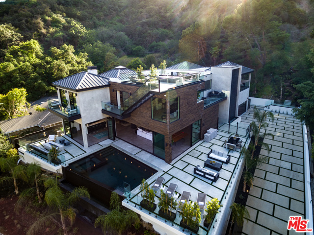 2031 Roscomare Road Los Angeles, California NEW PRICE. SUBMIT ALL OFFERS. NEW CONSTRUCTION. Unique opportunity to own this Bespoke Modern Tropical in prestigious, Bel Air. The 130ft driveway immerses you into this lush OASIS tucked high & behind the road. The indoor/outdoor flow expands out to the infinity edge salt water, heated pool & spa. Entertain with your Roof Top Deck, 6-Seat Theater, Bar, 150 btl wine rack, 2 firepits, BBQ, Meditation deck area & Outdoor bath to truly be ONE witn nature on this huge lot. The Kitchen centers a massive 15' Italian Leather Marble island with Wolf appliances including Espresso machine, Double oven, Steam oven, Recessed hood, Sub-Zero fridge & 3 wine fridges. The Master stuns with the transparent fireplace flowing to the stone tub & rain shower with body sprays & steam shower. CUSTOM White Oak Cabinets & Doors, Closets, Bathrooms with concrete & stone sinks, Terrazzo stone tubs, Smart-Home with Security, Sonos sound & Lighting.