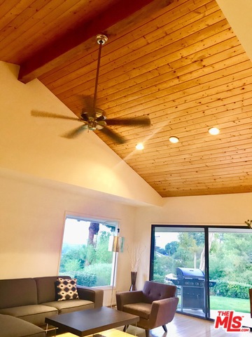 High wood paneled ceiling in Living Room