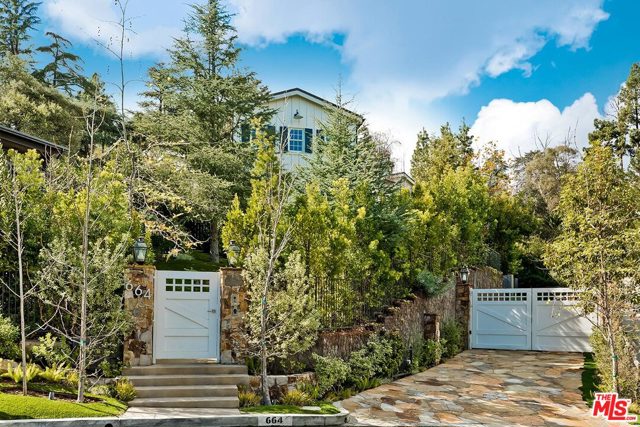 664 Elkins Road Los Angeles, California This magnificent California Traditional Farmhouse inspires a relaxed family lifestyle that is ideal for entertaining. The property has a lush gated entrance that brings you to a front covered patio w/ gorgeous fireplace. A dramatic formal entry opens to natural wood plank floors throughout, multiple fireplaces & beamed ceilings that add a warm appeal. The stunning chef's kitchen features marble countertops & top-of-the-line appliances, adjacent to the great room that serves as the family's cozy gathering space. The main level features a desirable private guest suite & upstairs boasts 5 en-suite bedrooms, including the grand bedroom suite w/ dual baths & closets w/ beautiful tree top/city views & a 2nd family room. An elevator connects the 3 levels of this grand residence & the lower level features a billiard room, plush theater w/ kitchenette/bar, workout room, walk-in wine cellar & 2nd laundry room. A gated driveway leads to a large 2-car garage w/ storage & direct entry to the home. The backyard is private & full of charm w/ several dining & sitting areas including a fireplace & outdoor kitchen. The hillside is an adventurer's getaway with multilevel seating w/ city light views that lead to the upper-level spa & canopy hammock overlooking the estate. Located on a large street to street lot in the coveted Oakmont HOA. This is a rare offering!