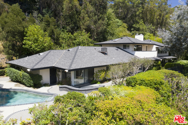 9545 Hidden Valley Road Beverly Hills, California Now $1 MM under original LP! Rare sprawling residence, flush w/ Mid-Cent Lloyd Wright-esque influences; deep overhanging eaves, floor to ceiling glass, clean lines & utter privacy, in 24/7 guarded Hidden Valley Colony. Recent sales at $17MM, yards away & other $30+MM valued homes, make this an ideal opportunity to expand/renovate/redevelop a large site w/gated drive or move in and get a toe hold as resident in the least expensive home to sell in the Colony in years. Multiple A-list Celeb enclave w/discrete clientele. 1st flr: open concept liv/din flows to generous patios & pool w/cyn views, plus 2 bds & 2 bas. Upstairs, enormous 2 bd/2 ba ste, superb bed ste/in laws. Topping it off: 2 blocks down this pvt rd is the residents only access gate to Franklin Canyon walking trails, lake & nature center, including vast seldom used open space. A green, pastoral environment, like living in Topanga or Malibu countryside, yet 5 minutes to the BH Hotel & easy access to Sherm Oaks/Studio City