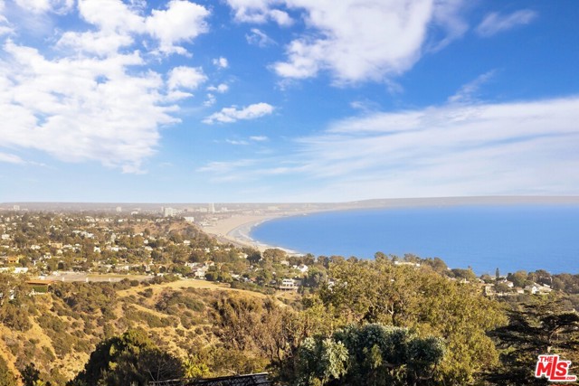 650 Resolano Drive Pacific Palisades, California Spectacular panoramic views throughout this gated Paseo Miramar home. Property is surrounded by nature with coastline, mountain, canyon, city and Queens Necklace views and has 5 extra off-street parking spaces outside of the 2-car garage. Minutes to beaches, trails, the Village, Santa Monica, and Malibu. Tastefully remodeled, this 4 bed, 3 bath home is situated on commercial grade caissons. Features Fleetwood sliders, large view decks, wood-burning fireplace, hand-distressed maple floors, dual pane windows, new carpeting, and more. The gourmet kitchen features Miele appliances, SubZero fridge, and quartz countertops. Enjoy outdoor dining on large deck facing ocean, canyon, and city views. Upper level consists of a large suite with bedroom, sitting room, wet bar, walk-in closet, master bath with large shower, dual shower heads, marble floors, jetted tub, and patio. LA2 is seller