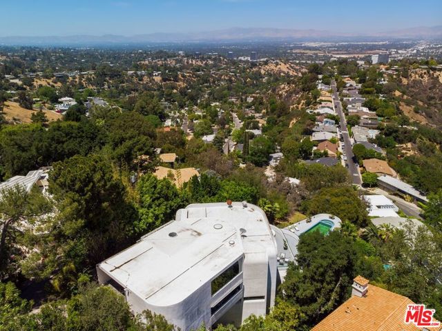 15105 Mulholland Drive Los Angeles, California This secluded and private, architectural masterpiece, known as the Bel Air Yacht Mansion, layers down the hillside above Bel-Air, on a little more than half an acre of land. This unique home was designed by world-renowned architect Glen Small. The bridged-design includes multiple entertainers decks with breathtaking and unobstructed jetliner city views as you sit atop the Mulholland Corridor. As you enter the eight-car private motor-court, you are greeted with floor to ceiling glass which leads to a beautiful reception area with city views, an elevator, and a guest suite. This landmark features a curving staircase, 26 rooms, and approximately 2,500 square feet of outdoor viewing decks. The property also includes a 46 foot color-changing lap pool with a hot tub, 5 bedrooms, 8 bathrooms, a theater room, 2 kitchens, a billiards lounge level, a club level with wet bar, wine & cigar room, and a master bedroom that includes: dual spa like bathrooms, walk-in closets, and a patio with a private hot tub. This prestigious mansion has been featured in films, TV shows and music videos featuring Snoop Dogg, Jason Derulo, Alicia Keys, Eve and many more! Many people including Prince, One Direction, and royals from around the world have called this place home. It has also hosted after Oscar & Grammy parties and has collected over $500K in rental income. Rates for this