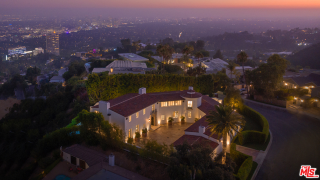 9240 Robin Drive Los Angeles, California Newly built and never occupied, this uniquely realized world class estate is on a quiet cul-de-sac in one of Los Angeles' most coveted neighborhoods with neighboring homes selling upwards of $40 million. Designed by award-winning architect Richardson Robertson III, renowned for "Fleur de Lys" in Bel Air, the home boasts striking views from downtown to the ocean, with meticulously designed interiors and finished with the finest European materials. Features include four bedrooms, eight baths, 800-bottle wine cellar, theater, library and a sparkling pool with skyline city views. The lavish master suite features fireplaces in the bedroom and sitting room capturing sparkling, top-of-the-world views. Unique to the area, a Porte cochere leads to lush, level gardens circling the grounds. A perfect combination of International luxury and glamorous Hollywood lifestyle.