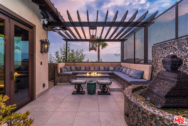 1380 Summitridge Place Beverly Hills, California Completely custom home with no expense spared priced to sell! With incredible views of Downtown LA and the Ocean, this home won't last. Designed by Kevin Young, this home offers 4 bedrooms, 4.5 baths, home theater and a recording studio with sound room. Dramatic interiors eloquently complement the impeccable 4-bedroom ensemble while a nearly 2,000 square-foot deck extends over the hillside. A masterpiece of its own accord, the stately formal dining room and custom chandeliers set the ambiance. Designed for leisure and enhanced entertaining, a two-screen drop-down projector system elevates the living room opening to a top-level deck, massive gas fire-pit and serene lounging space. Automated blackout curtains unlock your expansive views to the city and ocean while maintaining ultimate privacy. Complete with pitch perfect sound rooms, a recording studio and a barber shop that opens to a turf putting green and pool overlooking the picturesque cityscape.