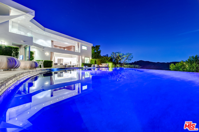 1518 BEL AIR Road Los Angeles, California The absolute ultimate in glamorous contemporary living. A true timeless masterpiece featuring the latest in technology and materials and infused with Old World class and spectacular magic. Completely remodeled and completed in 2014. A state-of-the-art open floor plan with grand open kitchen/family room and breakfast nook seating for 10, master wing w/extensive private outdoor covered patio w/fireplace and infinite his and her master baths and closets designed for today's royalty, home theater, office, 23' grand foyer ceilings and high ceilings throughout. 3 exquisite staircases, 70' quartz infinity pool spilling into a picture perfect view, remote controlled disappearing walls of glass seamlessly joining the outdoor living rooms and patios with the decadent grand rooms inside. Gated circular motorcourt for 10 cars w/oversized 3-car garage. Vacuum elevator. Extremely private with endless and breathtaking mountaintop views.