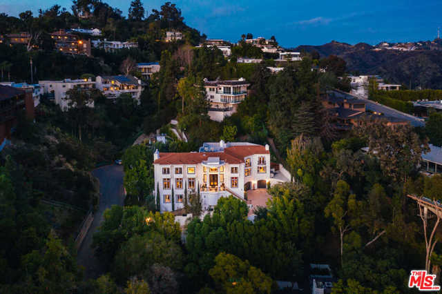 1404 Dawnridge Drive Beverly Hills, California A New Dawn is here - set high in sophistication and located minutes from the world-famous Beverly Hills Hotel, this reimagined estate pairs together the ultimate private villa with modern style and elegant presence. Perched high up on a private gated driveway Villa Dawn is on a world of its own, spectacular city light views extending to the ocean waters. An incredible entry, the double staircase is stately and commanding. Large living room is beautifully designed for private and spacious entertaining. Large dining room perfect for gatherings. A sexy private office with custom wainscoting. Adjacent is a nicely scaled family room and open and bright chefs kitchen enhanced with marble slab counters, stainless steel appliances and large center island. The lower level features a private home theater, concession corner and lounge. A private elevator can take you to the top level where a grand master suite awaits including a private fireplace, walk-in closet, totally reimagined spa.