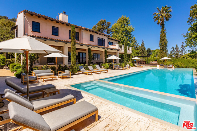 3100 Torreyson Place Los Angeles, California World Class Compound on 10+ acres. First time available in almost 20 years. Complete privacy, breathtaking views and sense of peace only minutes to the city. Built on what was once part of the Errol Flynn estate, this 13,530sqft Spanish Villa has always had an important Hollywood connection. Sited at the end of a cul-de-sac off Mulholland Drive, behind large gates and guard house, this is the ultimate hideaway. Recently renovated by renowned designer Estee Stanley, the interiors are a blend of modern and rustic elements. Youthful and fun, the main house offers an open floor plan, gourmet kitchen, gym, screening room, 7 bedrooms including a lavish primary suite. Epic outdoor living room wraps the house and provides the perfect backdrop for large scale entertaining. Grounds include guest house, 85ft long zero edge pool w/ plunge pool below, lit tennis court, meadow, forest, and farm-to-table vegetable gardens. A one of kind stately residence.