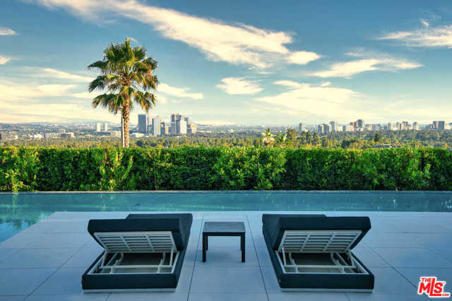 1251 Shadow Hill Way Beverly Hills, California This newly-constructed home in the heart of Beverly Hills is a triumph of style and design, showcasing 270 degree views from Downtown to the ocean. Located at the end of a cul-de-sac and walled in by mature trees, this estate offers privacy and tranquility. Renowned designer Joseph Ferrugio created a dynamic palate, from beechwood ceilings and walls wrapped in walnut to a backlit onyx bar, amethyst slab powder room, and elevator encased in a phenomenal resin chamber. Automated Fleetwood pocket doors capture far-reaching views and create a seamless indoor-outdoor flow to an expansive terrace with a distinctive 110 ft infinity pool and fire features. Floating stairs lead to the top level with a wraparound terrace, 2 guest suites, a spacious master suite with a sitting area, fireplace, showroom closet and gorgeous bathroom. A lower entertainers level holds a walk-in wine cellar, theater, wellness center, auto gallery, marble bar with a window to the swimming pool, and living green wall.