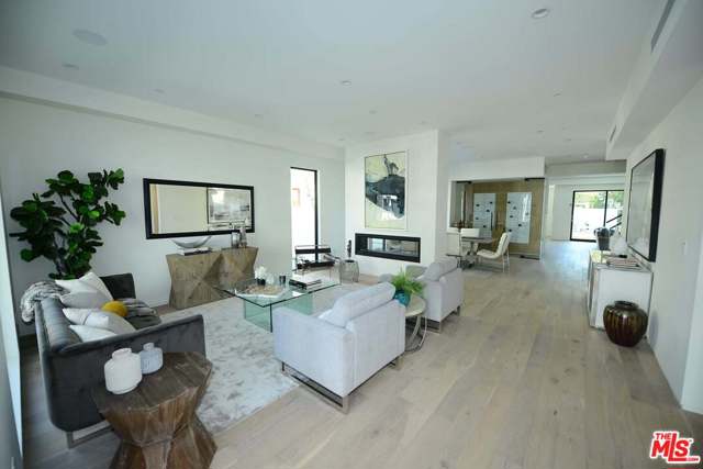 132 N Willaman Drive Beverly Hills, California Brand new 2021 modern construction in prime Beverly Hills. Located within walking distance and close proximity to restaurants, fashion promenade boutiques, museums, and parks, it brings a lot of positive emotions so desirable these days. The bright, airy, and wide-open floor plan consists of five en-suite bedrooms and the office/library. A magnificent chef's kitchen with top-of-the-line Miele appliances, custom European cabinetry, eat-in dining and enormous pantry. A floor to ceiling, glass encased wine room is attached to the formal dining area with a see through fireplace to the great room. Enjoy the surround sound and LED lighting with just a touch of a button on the living room smart pad. This home is a perfect showcase of the Californian living style of in-and-out hospitality. As you step out to the backyard you will be amazed by the Vegas-like fountains, luxurious pool and spa, built-in grill and fire pit, the bespoken designers' green walls, and multiple picnic areas that could quench the desires of the pickiest guests.