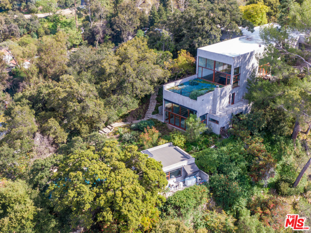 3201 Coldwater Canyon Lane Beverly Hills, California AD Published architectural compound sited on nearly 2 private gated acres. Enter into a dramatic 16' plus loft like open wood-beamed ceilings with floor to ceiling windows perfectly wrapped around a 180 degree city view of the Los Angeles Basin. This bespoke estate boasts an open floor plan, theatre, two additional detached structures with en suite baths, and a massive motor court. An abundance of natural light complements unobstructed views from every room, including the generous master suite with a sizable walk-in closet and sitting area. Step into tranquility out back, as you enter lush landscaping situated around a dramatic pool and spa with ample flat greenery.