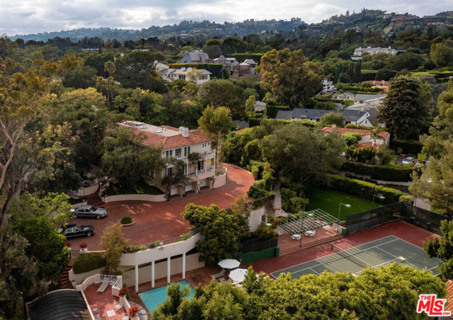1000 Ridgedale Drive Beverly Hills, California Architectural pedigree meets Old Hollywood. Once in a generation & rare opportunity to own an iconic estate steeped in entertainment history. The Fries Estate, once owned by Paramount Pictures, is an incredible promontory compound on appx. 1.2 acres w/ a legendary pool house designed by Paul Williams. Features: long gated driveway w/ massive motor court, main home has ideal floor plan w/ grand scaled public rms, primary w/ sitting rm, dual walk-ins, frplc + 2 en-suite bdrms up. 2 staff on main level. Lower level w/ huge theater, game rm, wine cellar, gym, staff rm & 2nd kitch. Your own personal Beverly Hills Hotel experience awaits. Enjoy days at the pool & pool house, create your own private Polo Lounge in the brick courtyard w/ fountain & enjoy walks in the park-like grounds & tennis in the N/S court w/ pavilion. Verdant landscape & mature trees envelope the home in privacy & create a magical backdrop for living/entertaining in style. The essence of quintessential Beverly Hills.