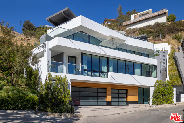 8661 Hillside Avenue Los Angeles, California Immaculate custom contemporary in prime Sunset Strip with stunning city views, oversized decks, rooftop pool and home theater. This striking home showcases a large formal entry with beautiful floating stairs and elevator servicing all floors. Continue to the 2nd story featuring 3 spacious en-suite bedrooms with a very large master suite and walk-in closet/dressing room. Master bath includes double vanities, oversized steam shower, floating ceiling above the spa tub and double vanities with floating shelves. The main living area is a large open floor plan epitomizing indoor/outdoor living. Walls of glass recede throughout, leading to spacious decks with sweeping city and ocean views. Kitchen features giant island, top-of-the-line Miele appliances, espresso machine and large double built-in wine coolers. This smart home includes a spacious 3 car garage with ample street parking. A separate APN/lot creates even more space and privacy. With impeccable attention to detail, the home truly offers it all.