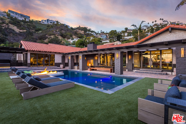 1707 RISING GLEN Road Los Angeles, California The most exquisitely conceived single-story estate with city/ocean/canyon views on one of the most sought after streets in the Hills. The owner spent more than $4M to remodel the home for himself, crafting a timeless masterpiece with soaring wood-lined vaulted ceilings, a master bedroom that turns into a movie theater, private library with a working bell-tower clock, master bath with 15 ft. dual-shower and unlacquered brass fixtures, custom sauna, copper outdoor tub, countertops and vanities made from solid steel, custom built and suede-lined walk-in closets, a hidden 85" living room TV that comes up from a concrete bunker under the house, floating stairs to a wine cellar, copper/steel custom bar with recessed steel and leather niches, four fireplaces, outdoor BBQ/bar, LED lighting and smart home technology throughout. An unrivaled chef's kitchen replete with Gaggenau appliances, Leicht imported German cabinetry, and Mavam coffee maker. Lighting throughout from Buster + Punch, London.