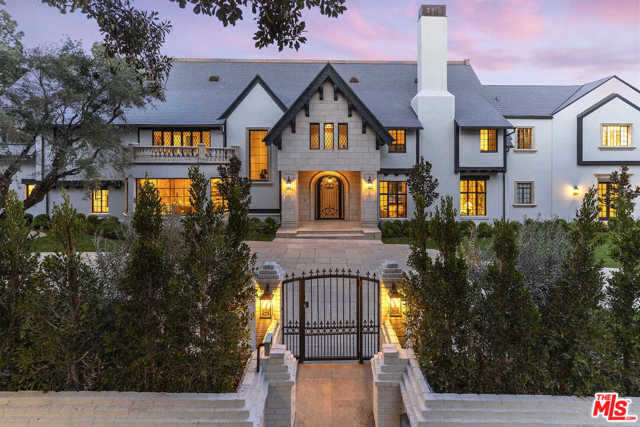 A grand and impressive Beverly Hills estate north of Sunset Blvd, this exquisitely crafted entertainers dream curates old-world elegance and modern-day sophistication. Once the home of silent film star Edward G Robinson, the house is adorned with ornate moldings and detailed woodwork from an era long ago. Lounge in the formal living room near the fireplace, entertain at the bar area, and spend time with family in the playroom. The backyard is a paradise with a pool, water slide, waterfall, spa, and stone patio surrounded by an expansive lawn and lush greenery. The open kitchen has a long butcher block island, marble counters, an oversized refrigerator, and a breakfast nook. The primary suite offers dual custom, walk-in closets, a patio, and a spa-like bathroom. With a formal dining room, library, fitness room, detached guest home, six fireplaces, and staff quarters, everything you need is at your fingertips. The Beverly Hills Hotel, Rodeo Drive and the LA Country Club are moments away.