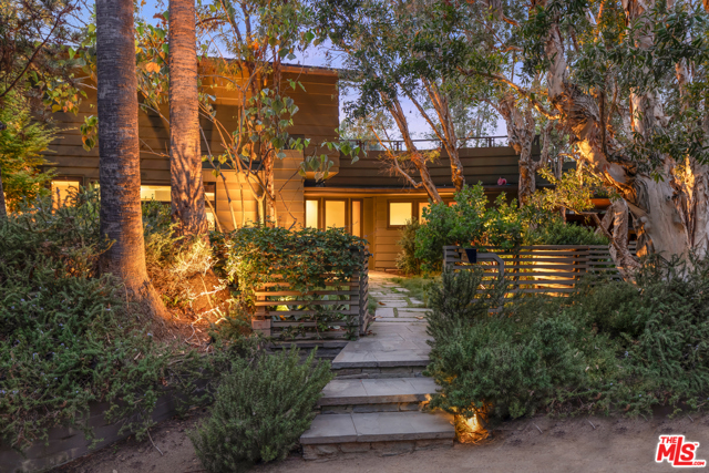 501 Latimer Road Santa Monica, California An architectural retreat, situated on an oversized corner lot in Santa Monica's coveted Rustic Canyon. Beyond the private gates, find yourself immersed in nature with lush landscaping, designed by Nancy Goslee Power, and mature trees. Through the front door, the tone is set with impressive wood paneling, thoughtful lighting, and floor-to-ceiling wall of custom library shelving. First floor features 3 bedrooms, ideally set away from the main living area. The dining and living rooms seamlessly connect and open to the large outdoor patio with dining area and built-in seating surrounding the fire pit. Contemporary, clean lines connect with the inviting curves of the ceiling alcove in the living room - one of the many examples of the exquisite attention to detail throughout. The oversized kitchen, flooded with natural light from the geometric-shaped skylight, features a breakfast nook, stainless steel appliances, and fireplace. Upstairs includes the private primary suite, with a separate office, expansive bedroom with fireplace and balcony, master bath, and large walk-in closet. Beyond the main house, the backyard is an entertainer's dream with gorgeous grounds, two dining areas, BBQ, wood-fire pizza oven, pool and spa, and the guest house with kitchenette and full bath. Moments from the beach, shops, restaurants, and down the street from Rustic Canyon Park.