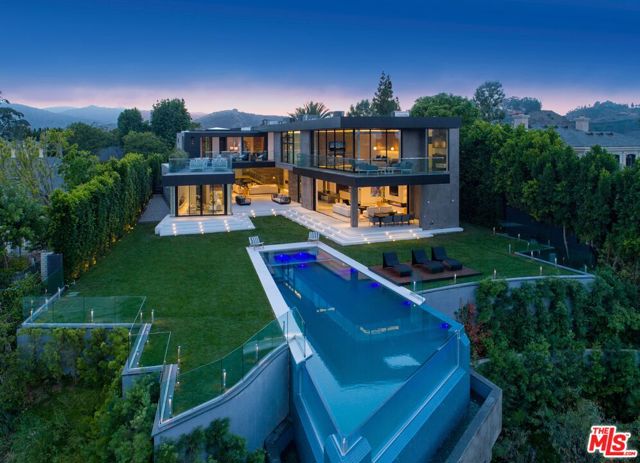 11507 Orum Road Los Angeles, California Set on a quiet cul-de-sac in Bel air, this Architectural Estate has spectacular city, mountain and ocean views. Behind the gates you'll find complete privacy from all areas, soaring ceilings and automatic Fleetwood glass pocket doors that showcase unobstructed views, creating the ultimate indoor/outdoor experience. The first level includes a spacious great room, formal dining room with fireplace, catering kitchen with dual islands and top-of-the-line stainless appliances, state-of-the-art movie theater, gym, saltwater aquarium, office and three-car attached garage. Also includes a family room with walls of glass that disappear into an al fresco dining patio area with incredible city and ocean views. The private grounds span approximately 1.3 acres, featuring a sprawling lawn and infinity-edge pool with panoramic views. Upstairs, the ultra-private master suite offers a sitting room, dual baths, showroom closets and wrap around balcony with seating area and views. Additional two ensuite bedrooms showcase unobstructed jetliner views and terraces and a guest suite with separate seating area. An entertainer's dream home.