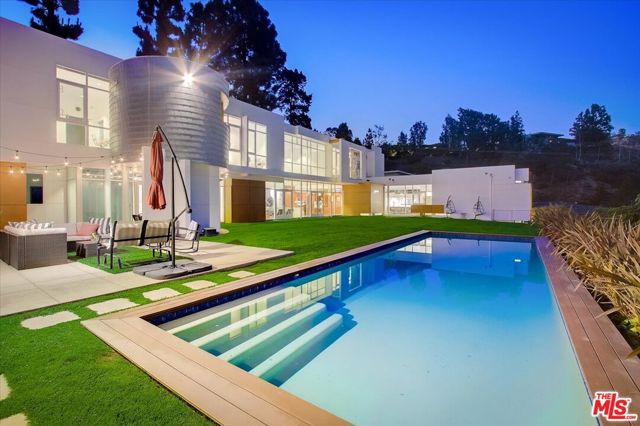2271 Betty Lane Beverly Hills, California Seldom does an architectural triumph like this come to market. Designed and built for himself by acclaimed architect Larry Schlossberg AIA. On a serene cul de sac with a prestigious Beverly Hills, 90210 address. Floor to ceiling walls of glass, polished cement floors and sky high ceilings to 21 feet. In addition, blank canvas walls for the accomplished art collector. Large open floor-plan with massive gourmet kitchen and professional, stainless steal appliances. Primary Suite with glorious views overlooking the expansive backyard and beyond. Stunning exterior with maintenance free Proderma wood cladding and aluminum shingles. Gym, study, maids, massage room and more. The beautiful, entertainment pool house, is perfectly sited next to the expansive, heated swimming pool. All this and more, with a moments drive to the incredible shopping of Rodeo Drive and all that Beverly Hills has to offer.